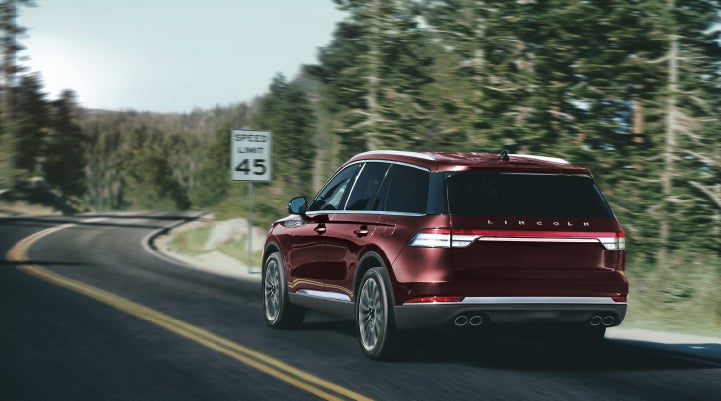 A 2024 Lincoln Aviator® SUV is being driven on a winding mountain road | Doral Lincoln in Doral FL