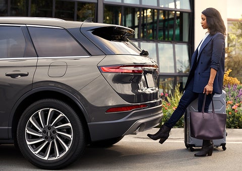 A woman with her hands full uses her foot to activate the available hands-free liftgate. | Doral Lincoln in Doral FL
