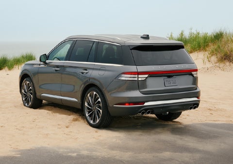 A 2027 Lincoln Aviator® SUV is parked next to sand dunes. | Doral Lincoln in Doral FL